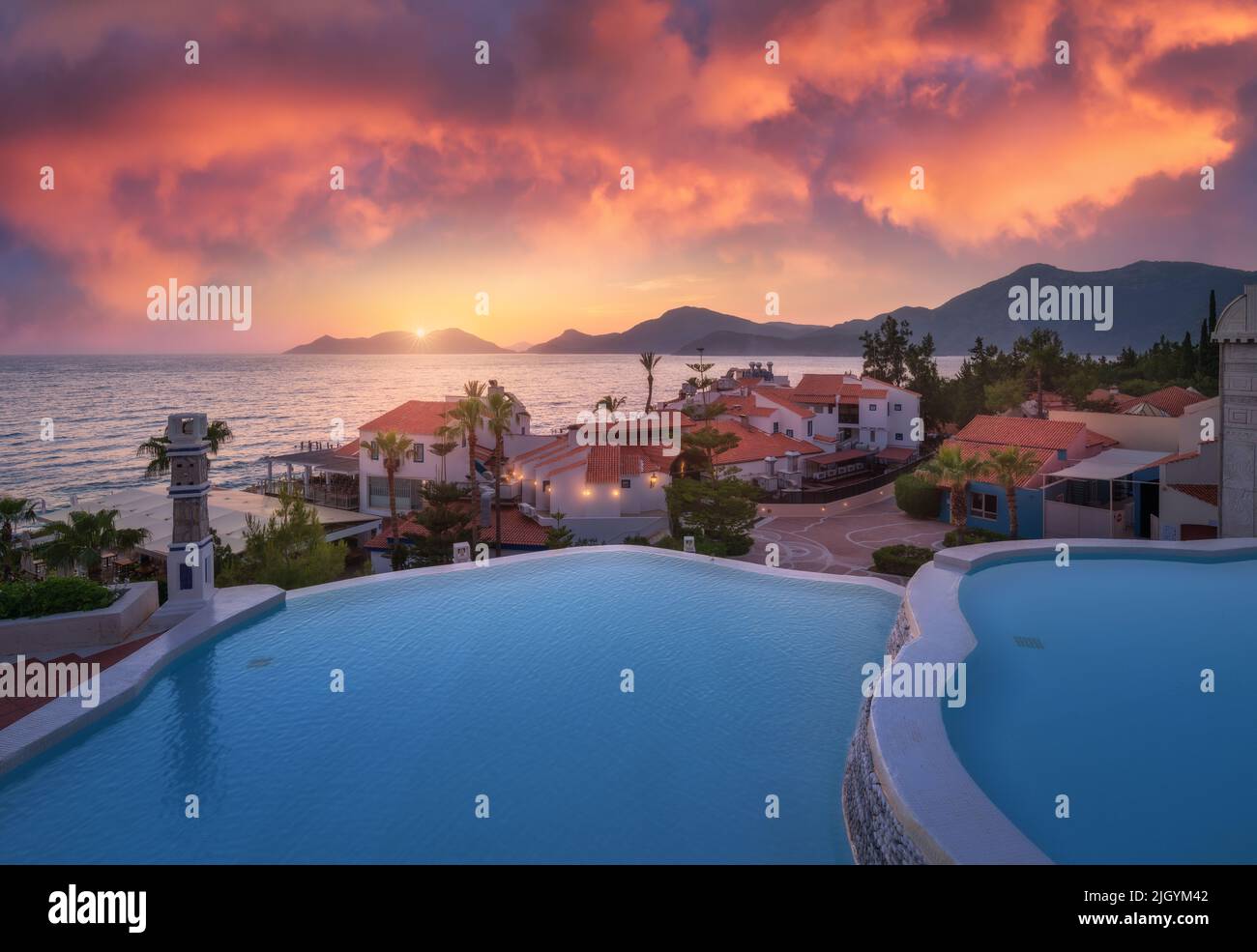 Beautiful swimming pool, sky with pink clouds at colorful sunset Stock Photo