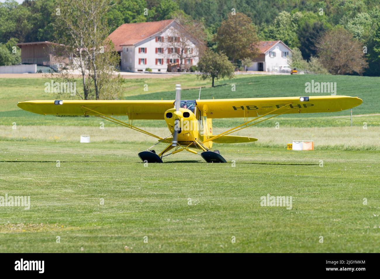 Lommis, Switzerland, May 11, 2022 Piper PA18-150 Super Cub propeller plane is taxiing on the grass on a small airfield, Stock Photo