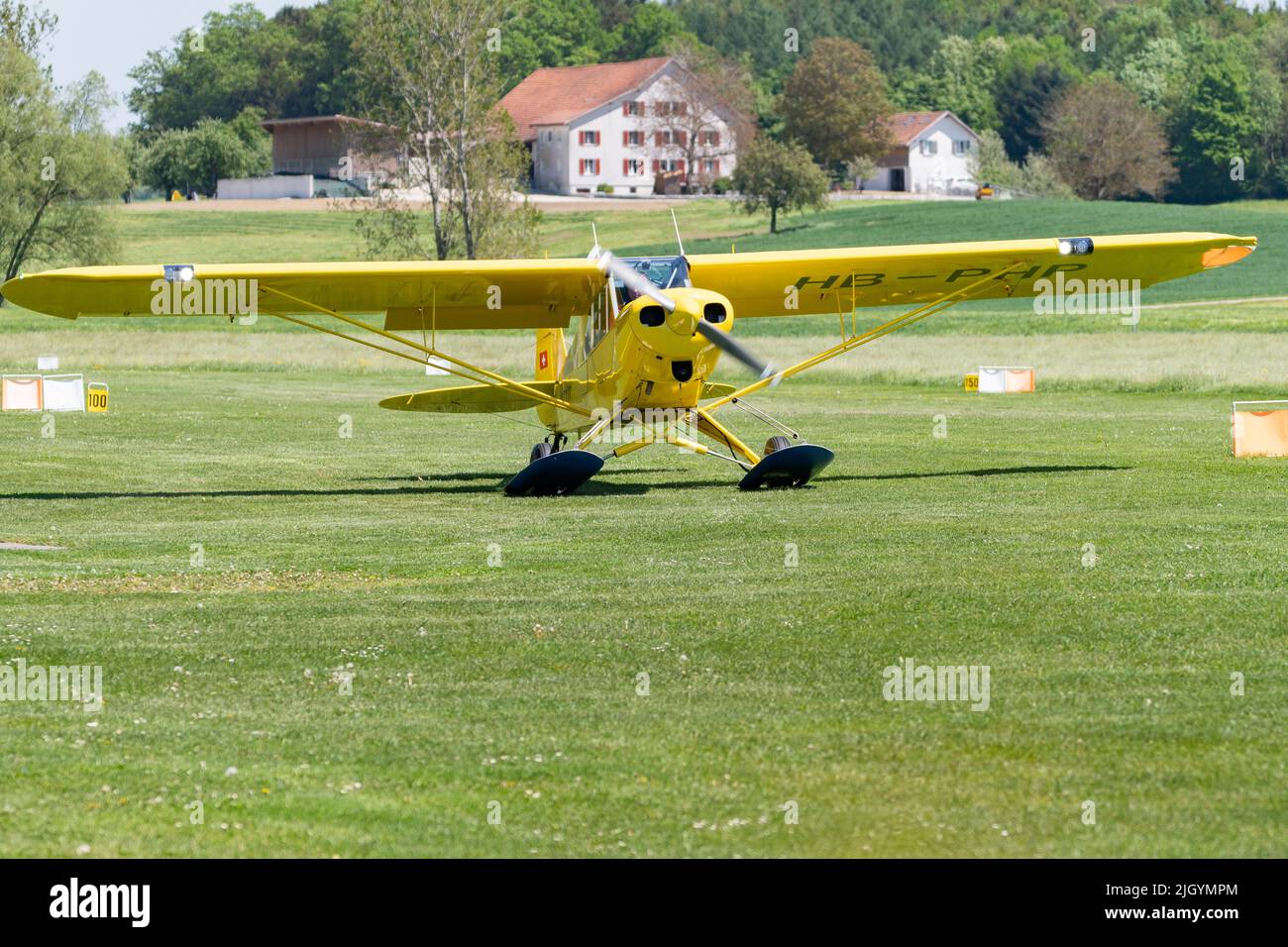 Lommis, Switzerland, May 11, 2022 Piper PA18-150 Super Cub propeller plane is taxiing on the grass on a small airfield, Stock Photo
