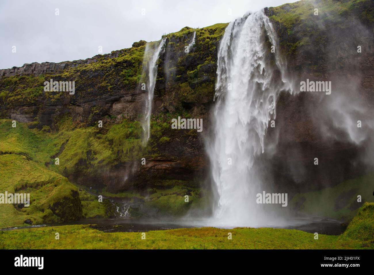 Trong winds rip at the Seljalandsfoss Waterfall in South Iceland blowing the 60 meters (200 feet) falls in all directions. Stock Photo