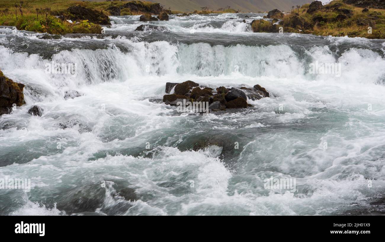 A few miles past the Foss a Sidu waterfall along the ring road, Þjóðvegur 1 from Vik to Höfn the river Fossálar cascades down towards the ocean. For s Stock Photo