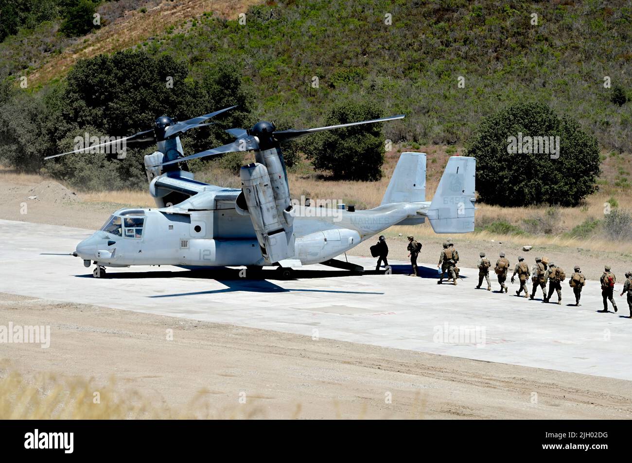 U.S. Marines board a MV-22 Osprey after it landed on a recently repaired runway during Operation Turning Point on Vandenberg Space Force Base, Calif., June 16,  2022. The Osprey quickly touched down, loaded personnel, and took off in  order to test the runway for viability following repairs to it. (U.S. Space  Force photo by Airman 1st Class Rocio Romo) Stock Photo