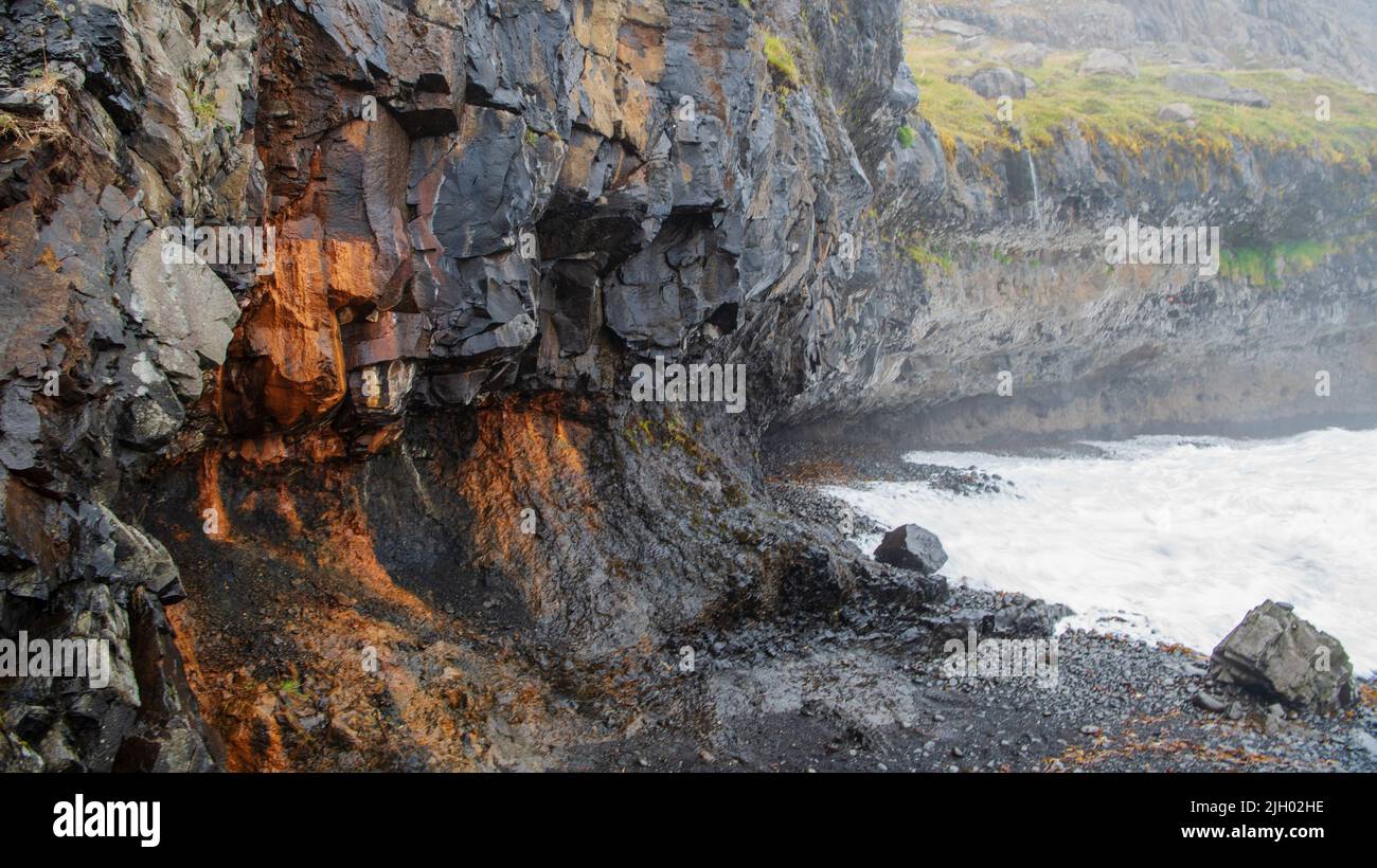 Páskahellir is a small cave by the seaside of Neskaupstaður Nature Reserve, with pillow lava and rock tunnels. You can also find holes that were proba Stock Photo