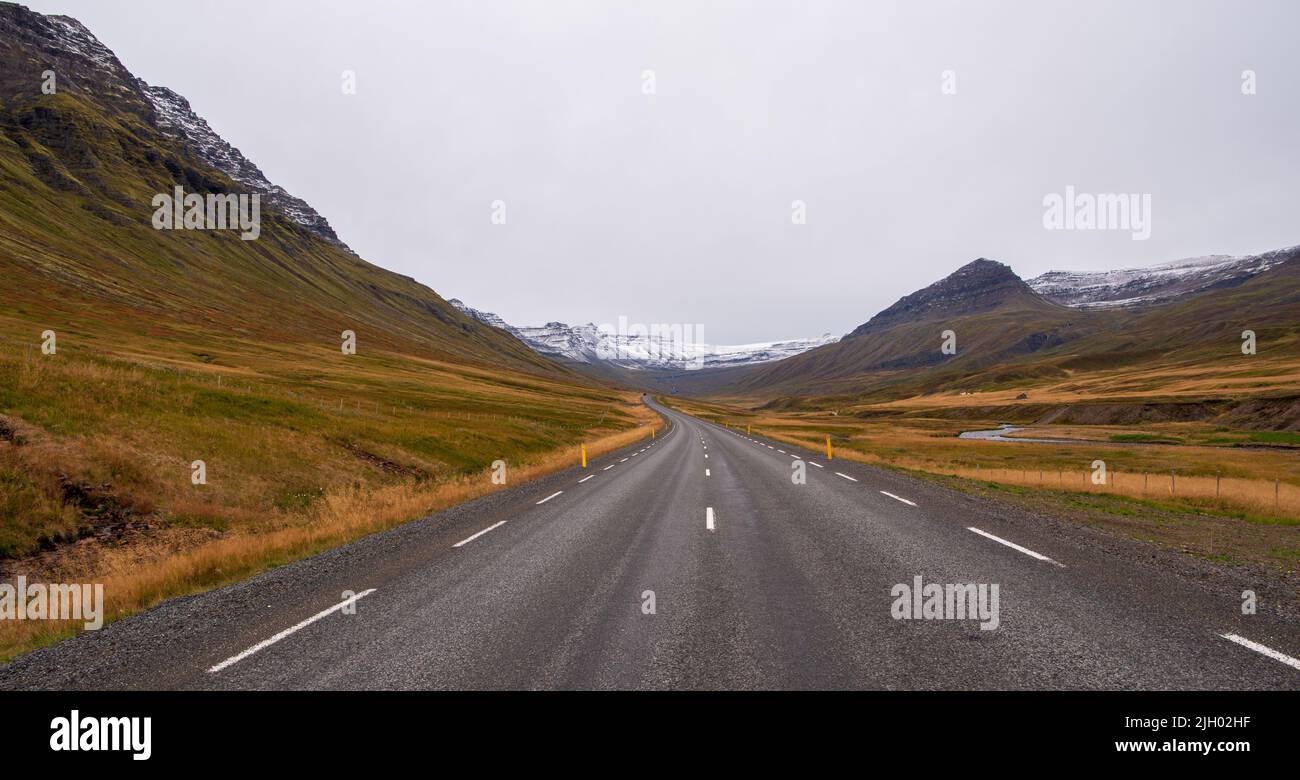 The west entrance to the Norðfjarðargöng tunnel on Iceland Route 92 can be seen in the distance. The tunnel crossing the highlands between Eskifjörður Stock Photo