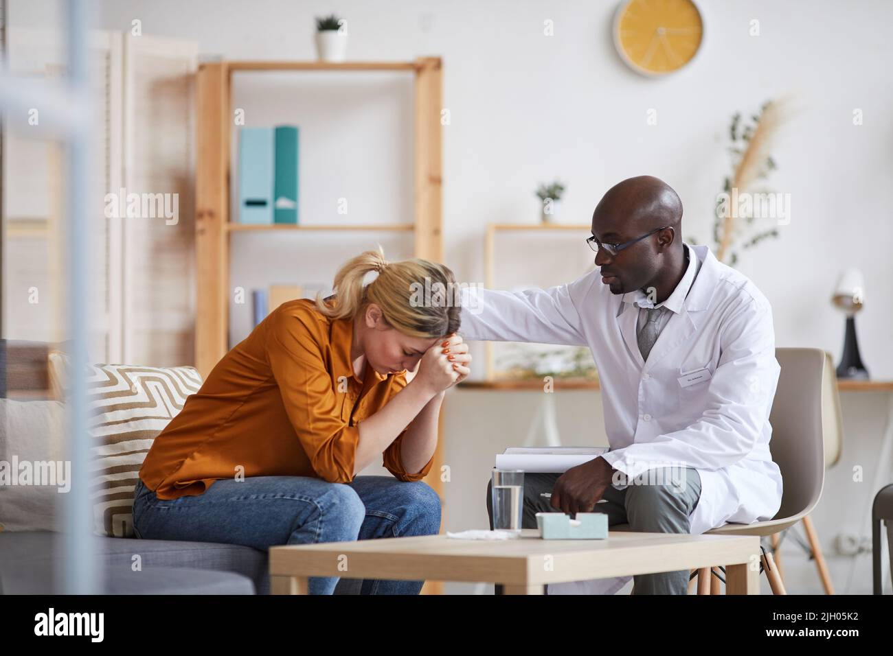 Understanding young Black psychiatrist in white coat and glasses