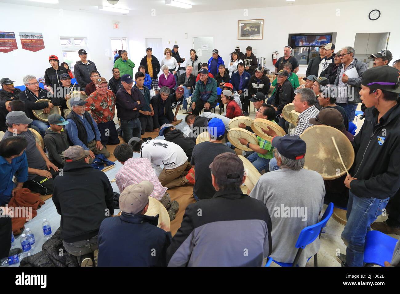 Dene Indigenous men drumming and playing traditional handgames in the
