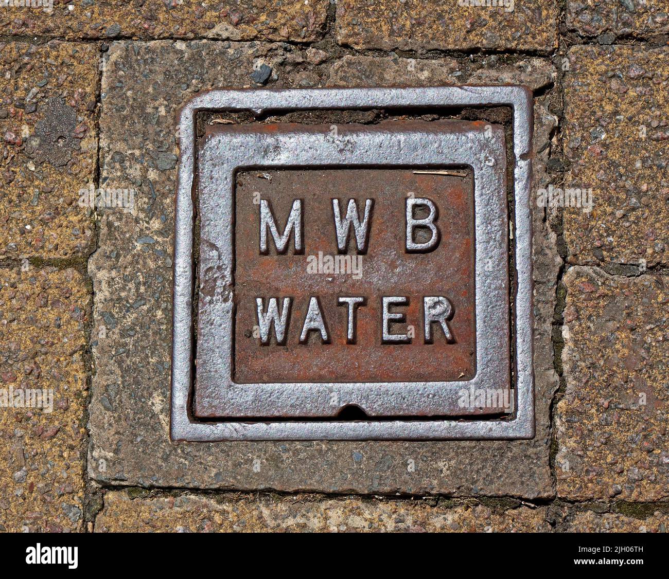 Embossed rusting cast iron grid, MWB Manchester Water Board, in Leigh town centre, Lancs, England, UK, WN7 Stock Photo