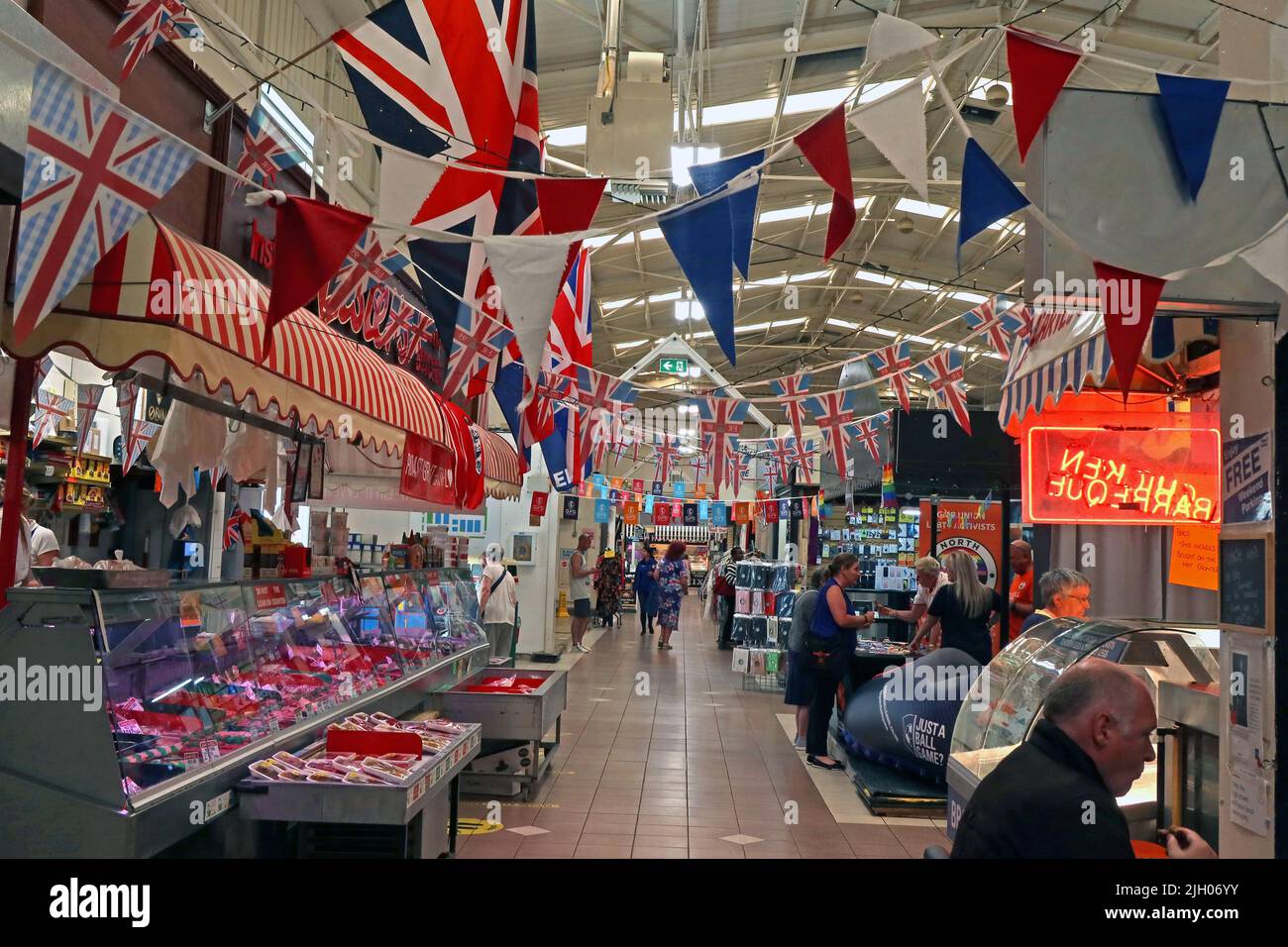 Butchers & meat for sale, Leigh covered indoor market hall with flags / bunting, Gas St, Leigh, Lancashire, England, UK,  WN7 4PG Stock Photo