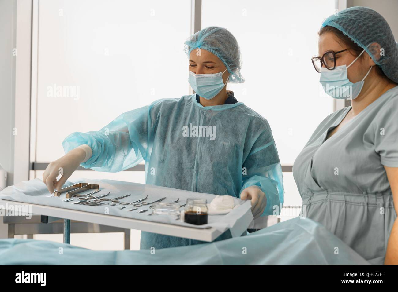 Doctor and nurse examining table with surgical instruments before the operation Stock Photo