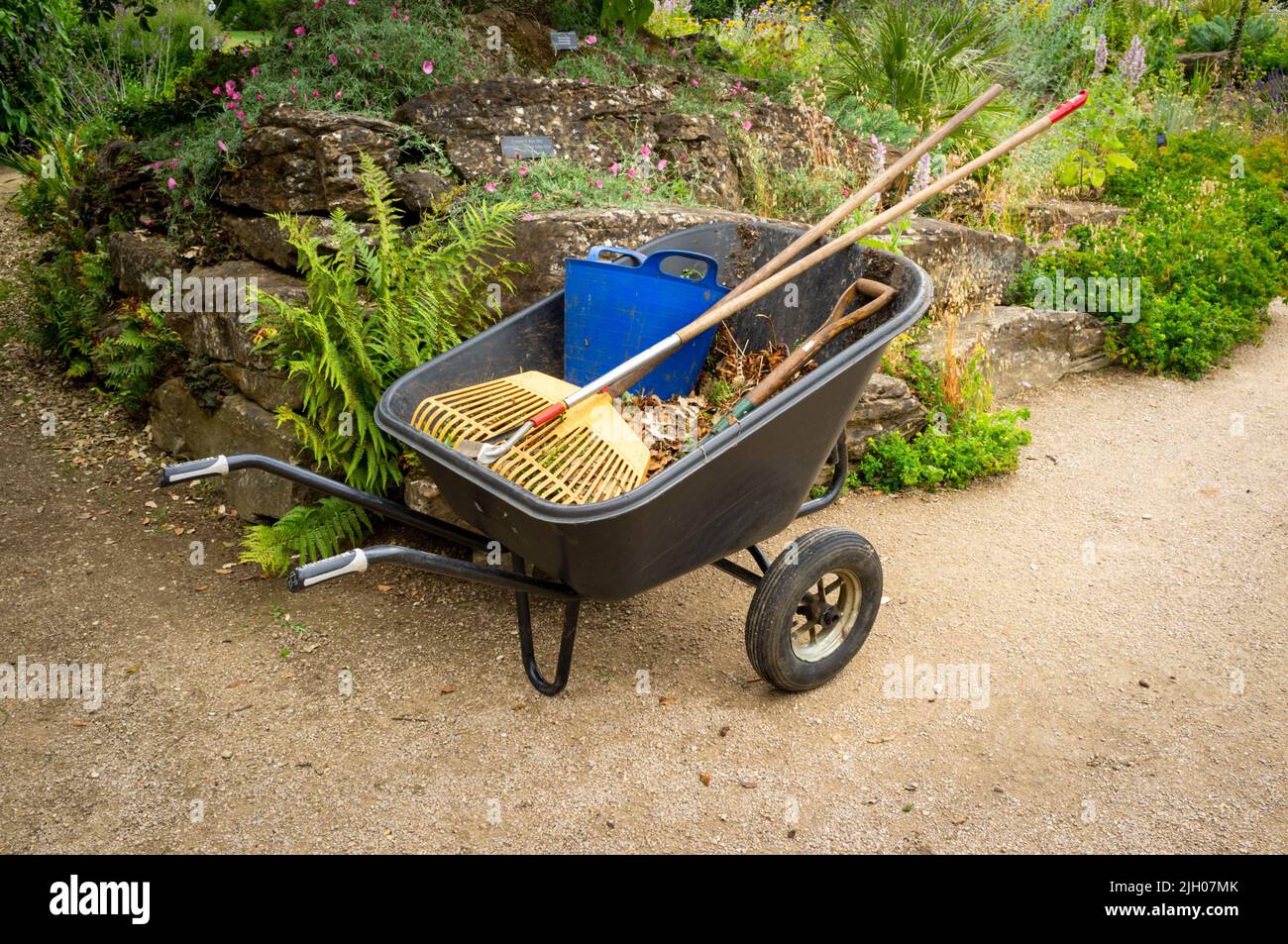 Professional gardeners tools and wheelbarrow in a park, UK Stock Photo