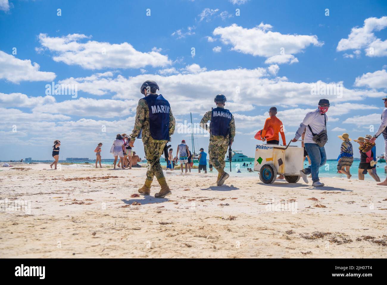 Militaries walking along the beach with machine guns, Isla Mujeres