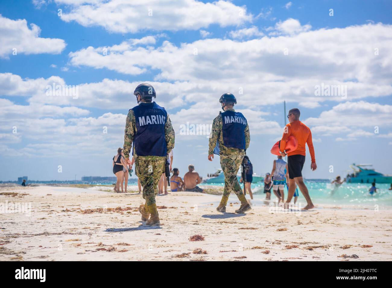 Militaries walking along the beach with machine guns, Isla Mujeres