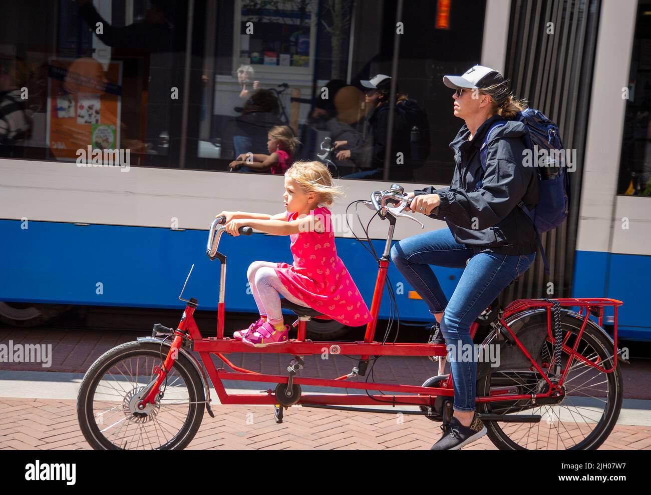 Mother and daughter on a tandem bicycle on an Amsterdam bike path Stock Photo