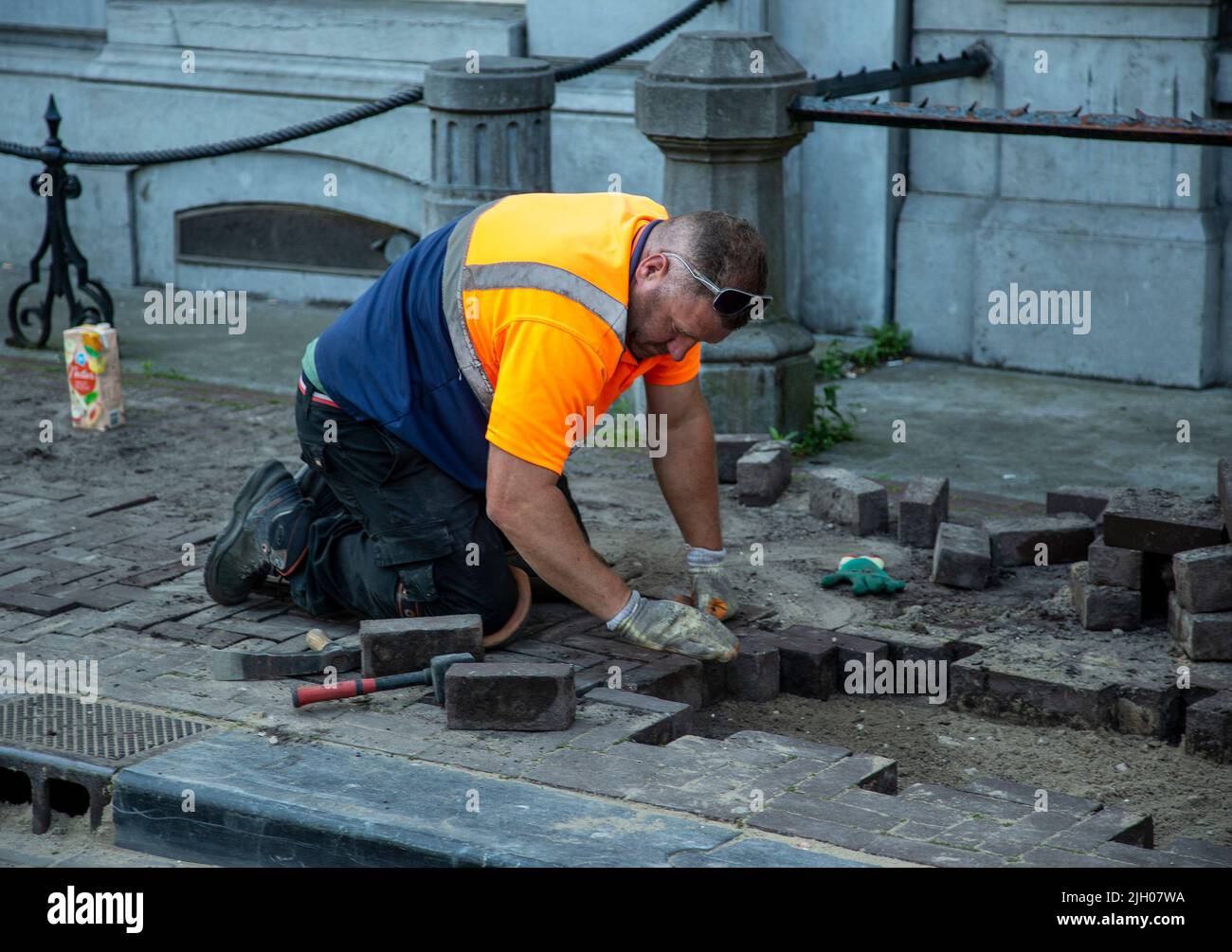 Worker repairing cobblestones on an Amsterdam street Stock Photo