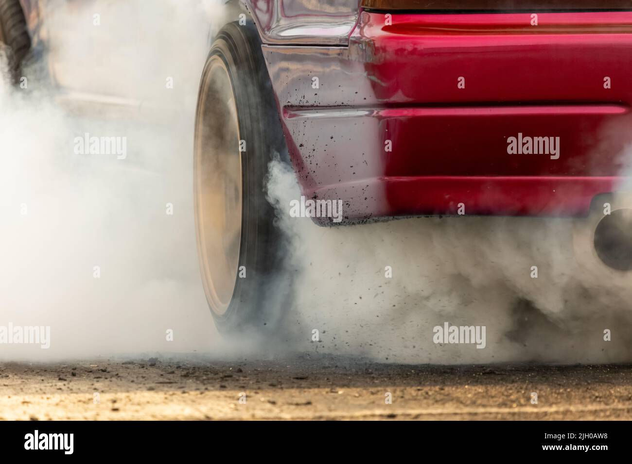 Drag racing car burns rubber off its tires in preparation for the race ...