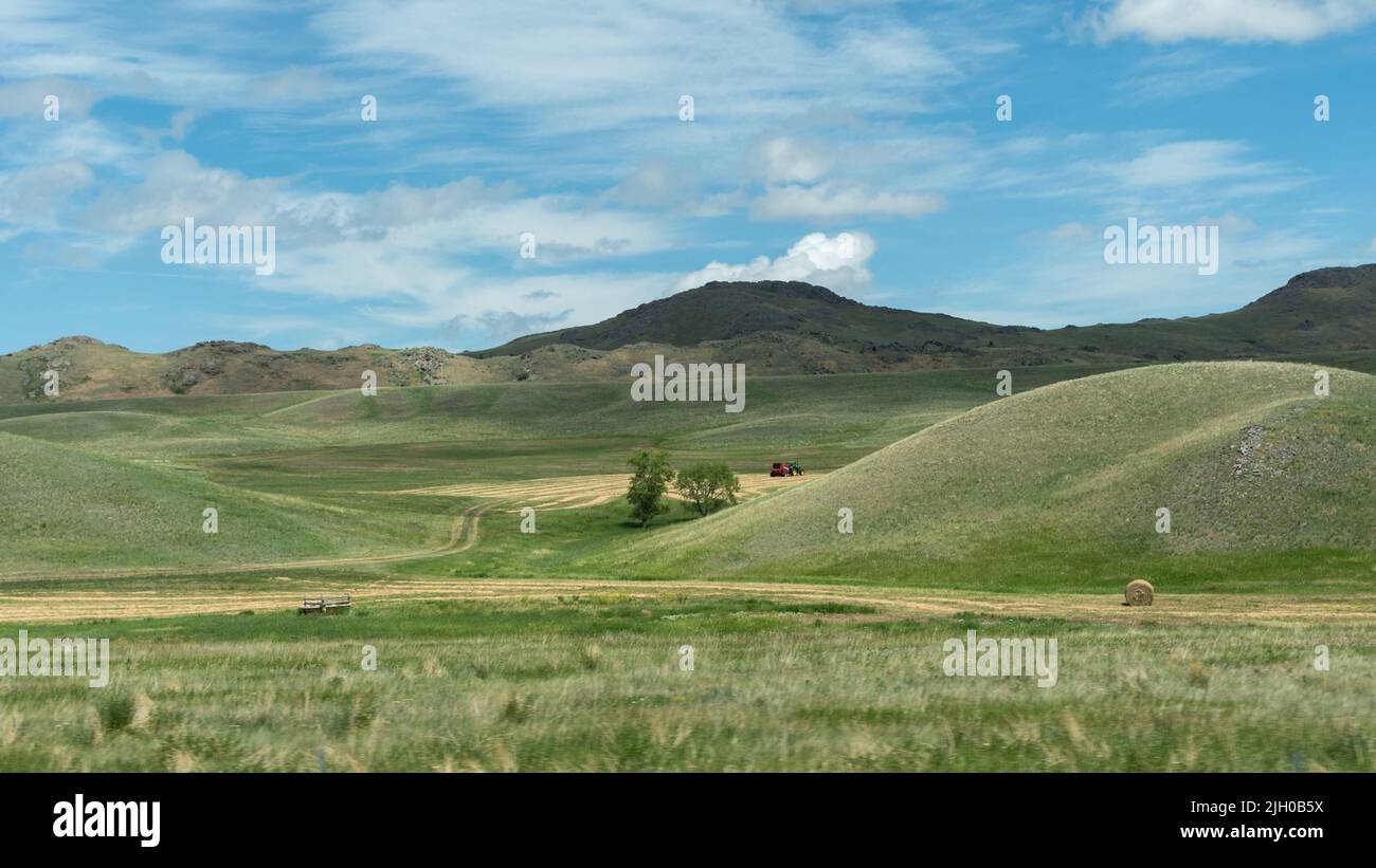 A tractor at work in the rolling green hills of western Montana Stock ...