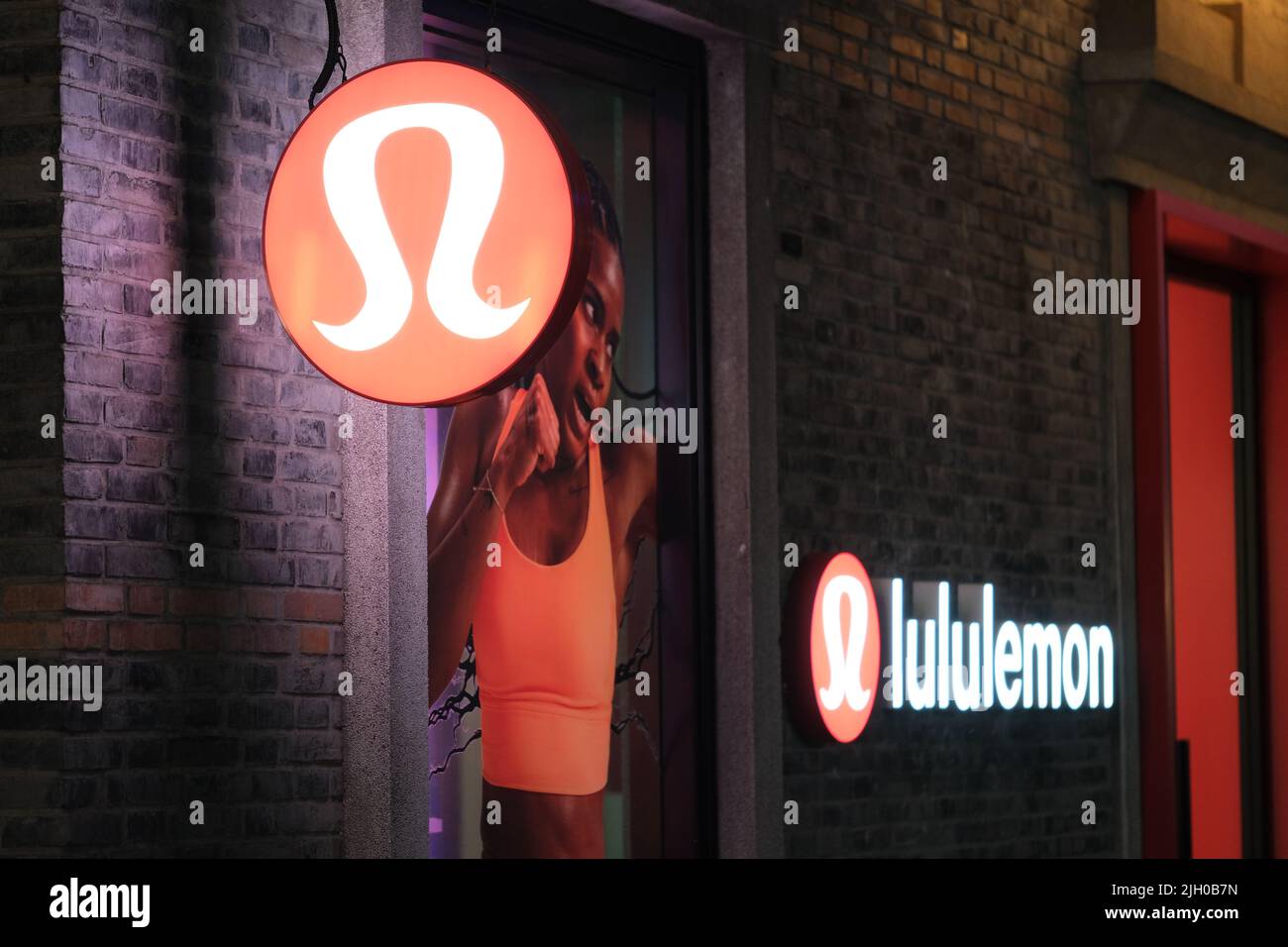 Shanghai,China-Feb.20th 2022: Lululemon Athletica brand sign at night outside store. Stock Photo