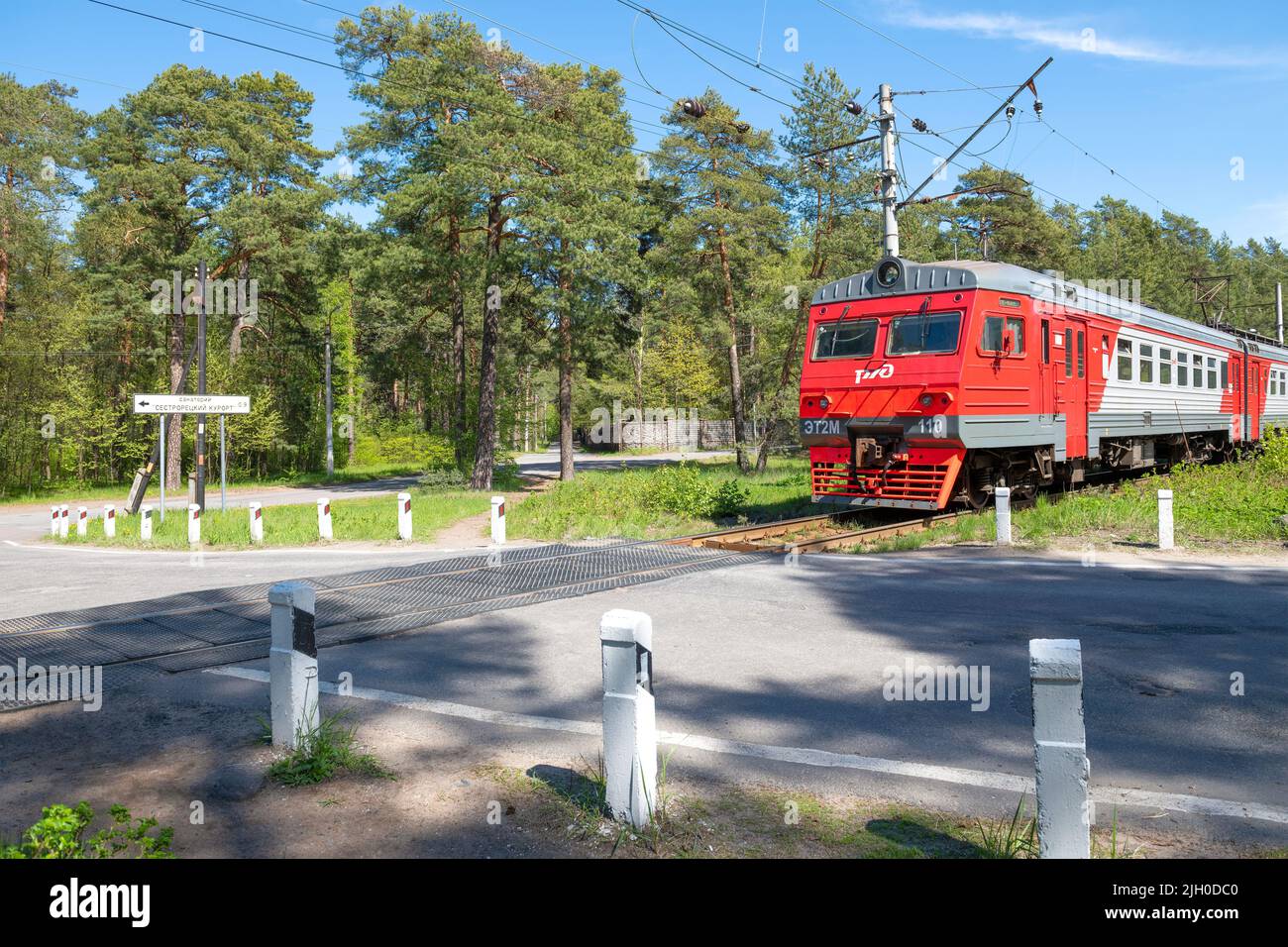 SESTRORETSK, RUSSIA - MAY 29, 2022: Suburban electric train ET2M-110 at an unregulated railway crossing on a sunny May day Stock Photo