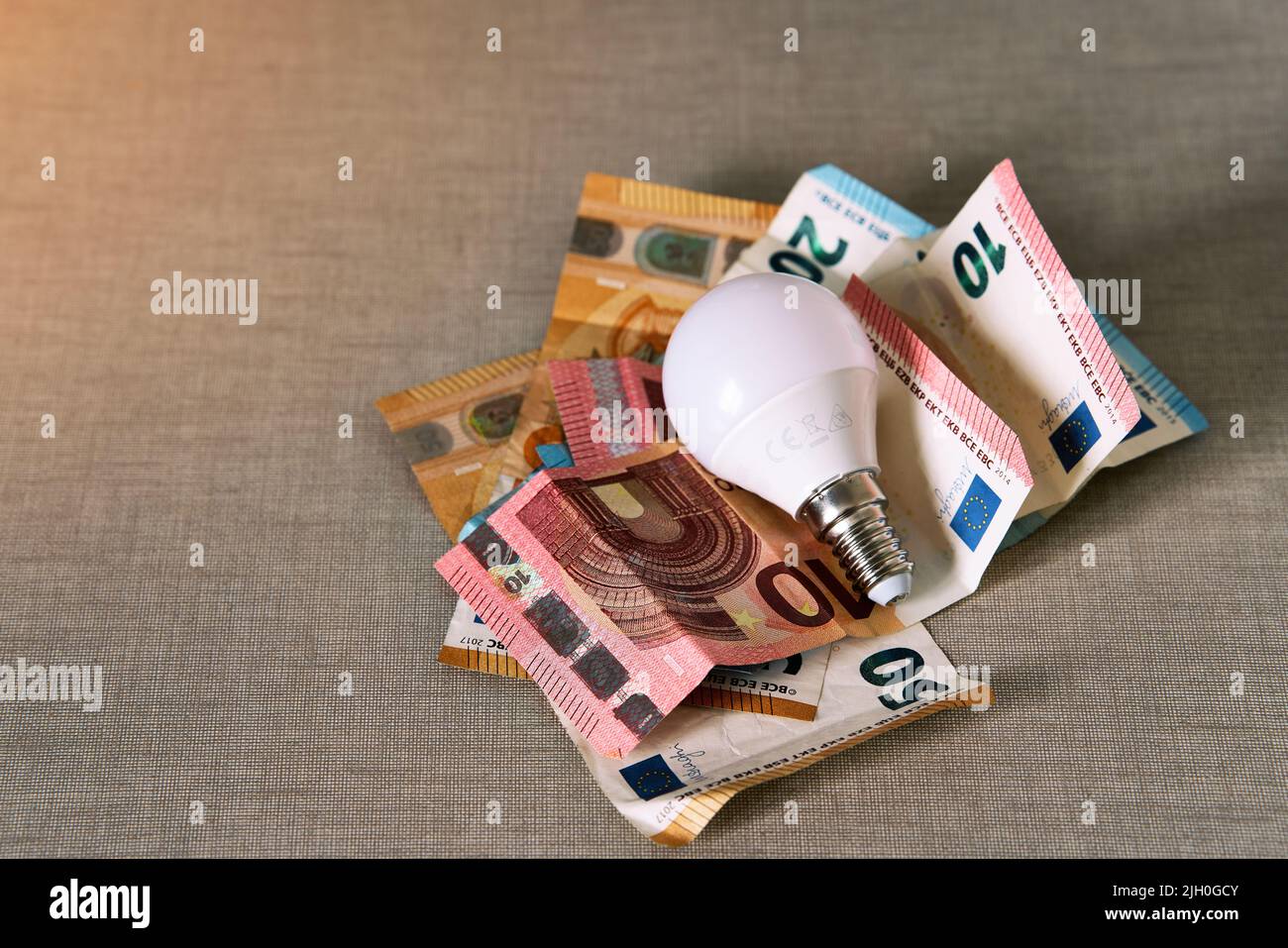 Several euro bills with a light bulb representing the rise in the price