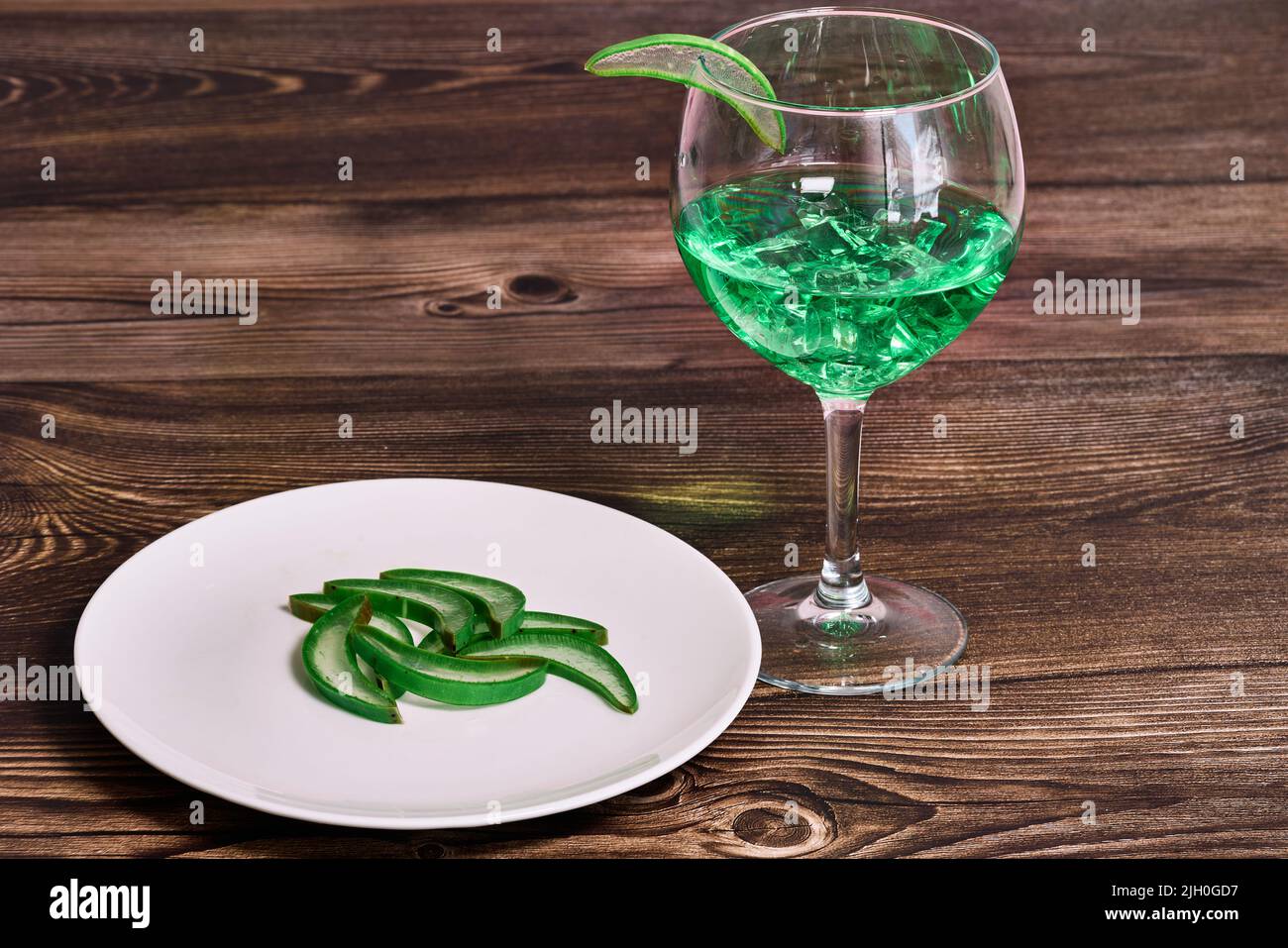 Cup with refreshing green liquid and a slice of aloe vera Stock Photo