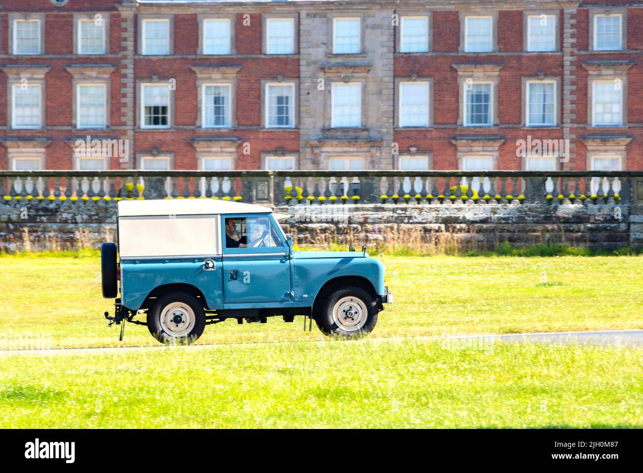 classic green Land rover 110 Landy driving in front of Weston House shifnal shropshire Stock Photo