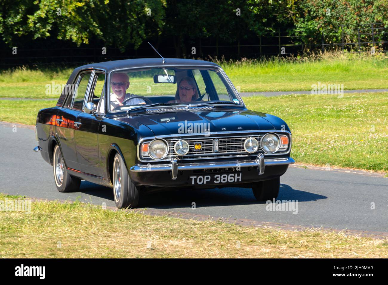 1970 vintage classic Black Ford Cortina Mark 2  driving on road Stock Photo