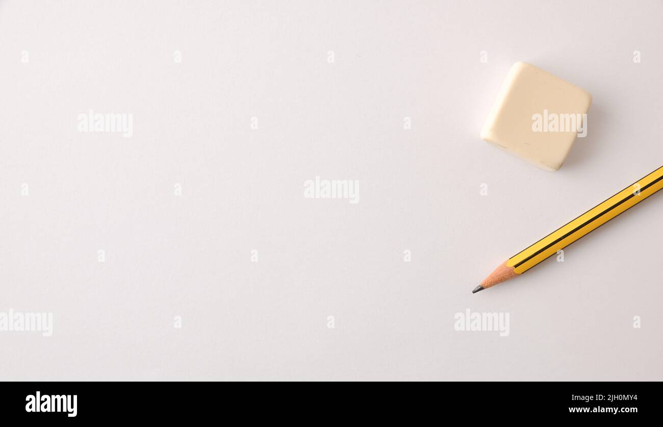 Teaching and education background with pencil and eraser on white paper. Top view. Stock Photo