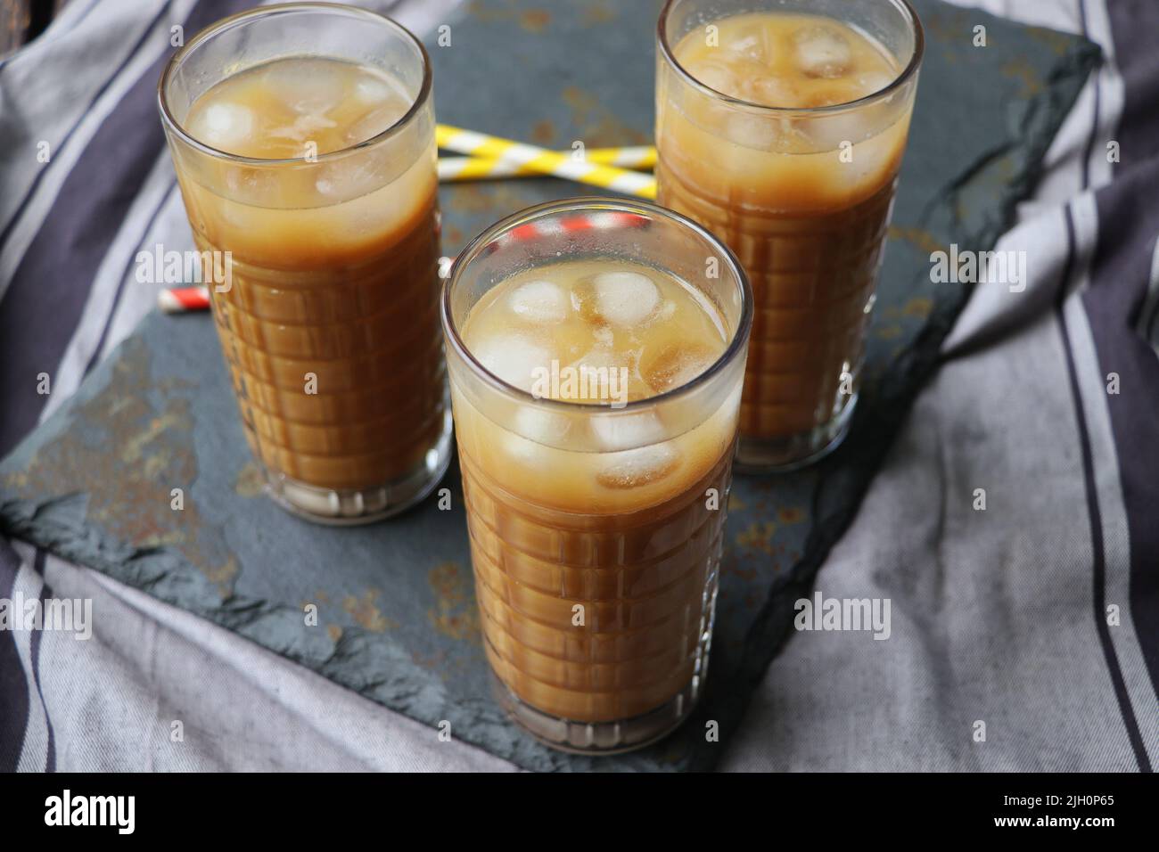 Summer drink iced coffee in tall glass on rustic wooden background. Selective focus Stock Photo