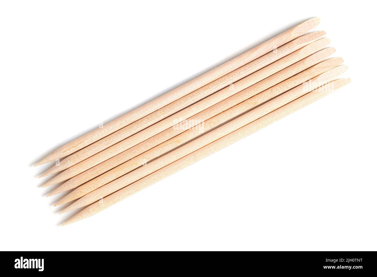 Orange wood cuticle pushers isolated on white background. Manicure instrument. Stock Photo