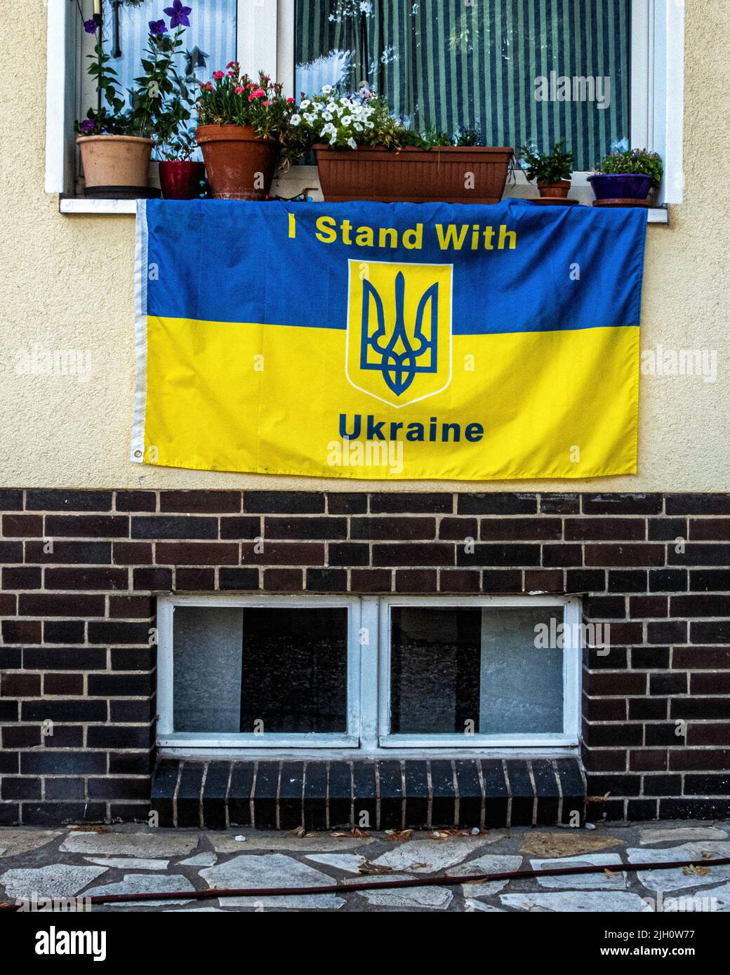 Blue & yellow 'I stand with Ukraine' flag on facade of apartment building in Stubenrauchstrasse, Rudow, Neukölln, Berlin, Germany Stock Photo