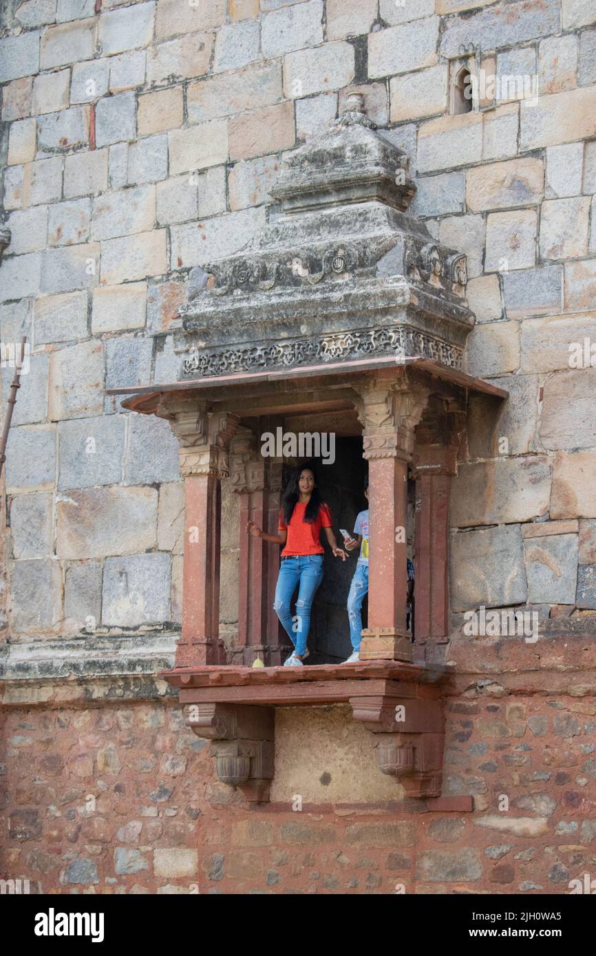 People are standing at antique type window from the old Indian fort which is known as Bara Gumbad at Lodhi Garden , New Delhi ,India Stock Photo
