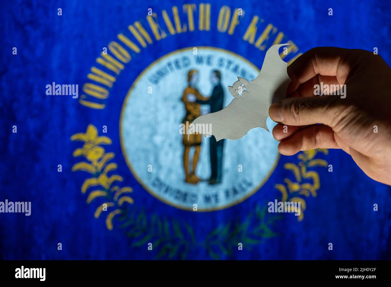 Happy Halloween, Kentucky. Male hand holds bat figurine. Kentucky state