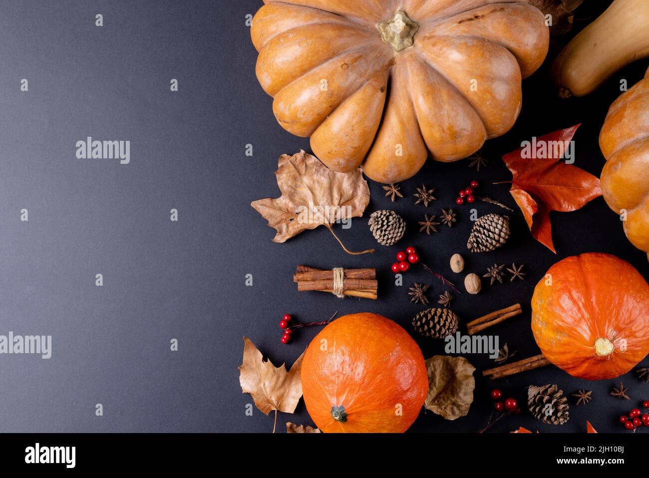 Composition of pumpkins with autumn leaves, pinecones and spices on ...