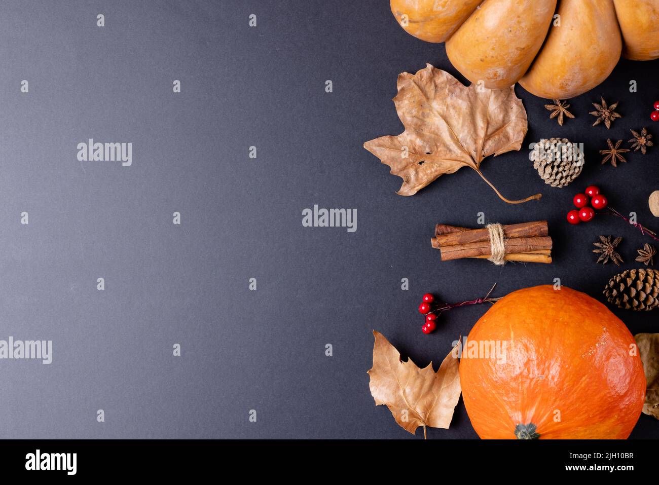 Composition of pumpkins with autumn leaves, pinecones and spices on ...