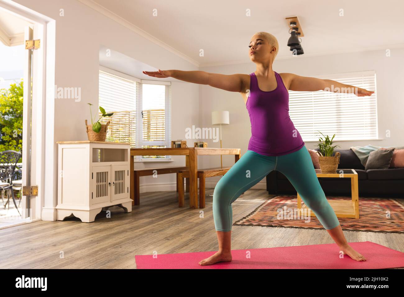 Image of biracial woman practicing yoga at home Stock Photo