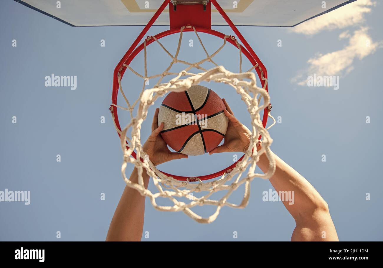 basketball player throws the ball into the hoop on sky background, targeting Stock Photo Alamy