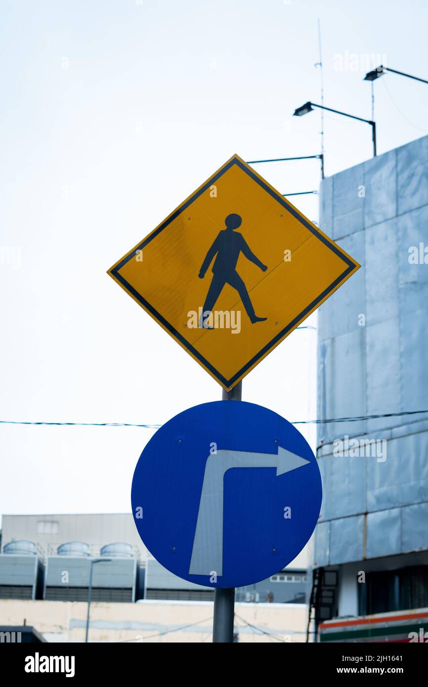 The vertical view of a blue street sign showing to turn right and a