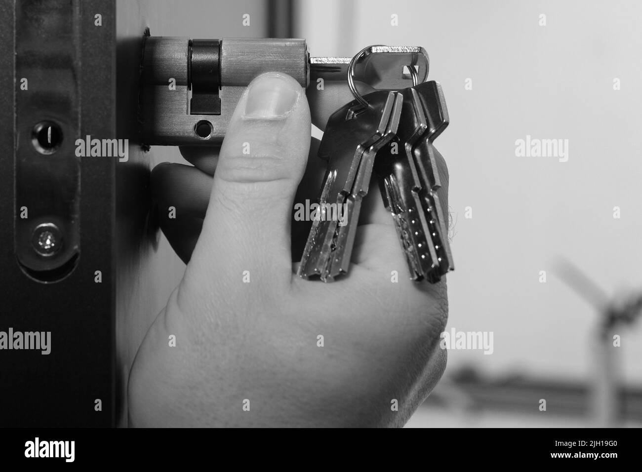 Worker installs new door lock Black and White Stock Photos & Images - Alamy