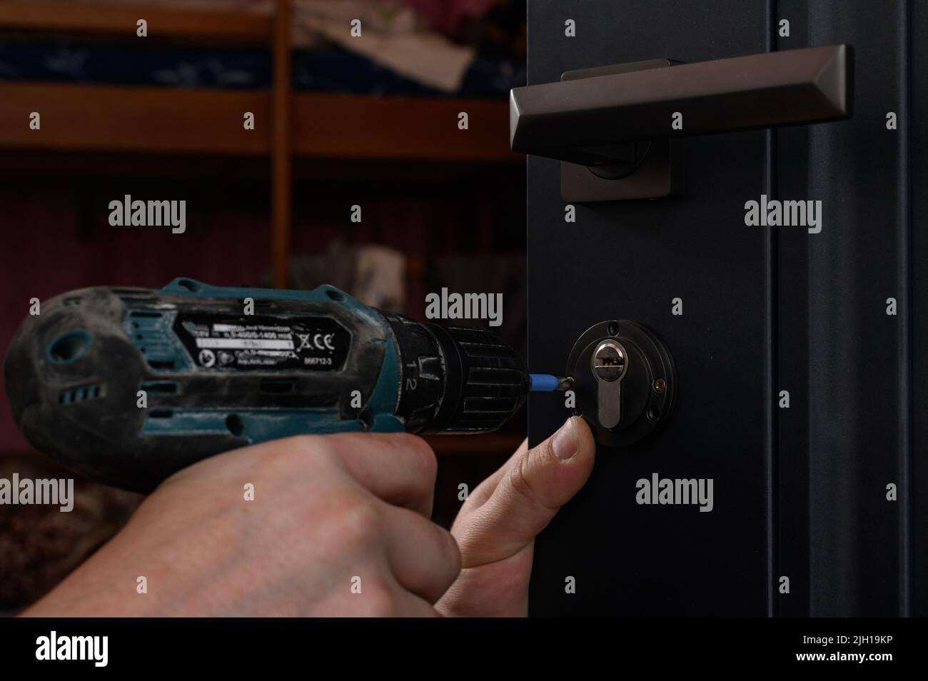 Installation of a door lock, a carpenter installs a door lock in a door