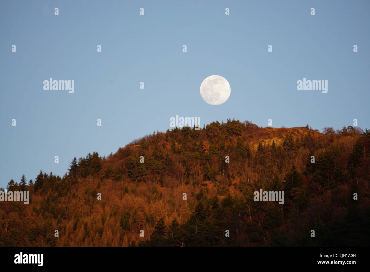 full moon rising on the mountains of the alps france in the fall Stock Photo