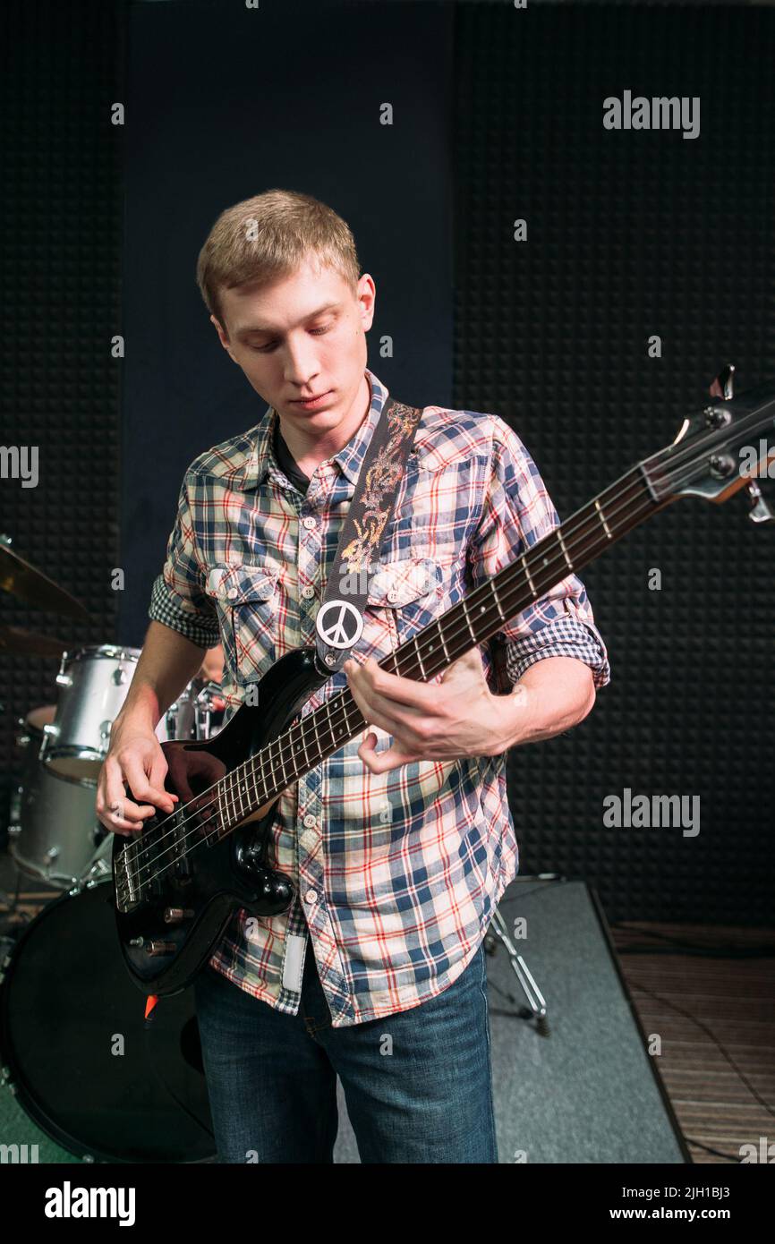 Young guitarist playing music in studio Stock Photo