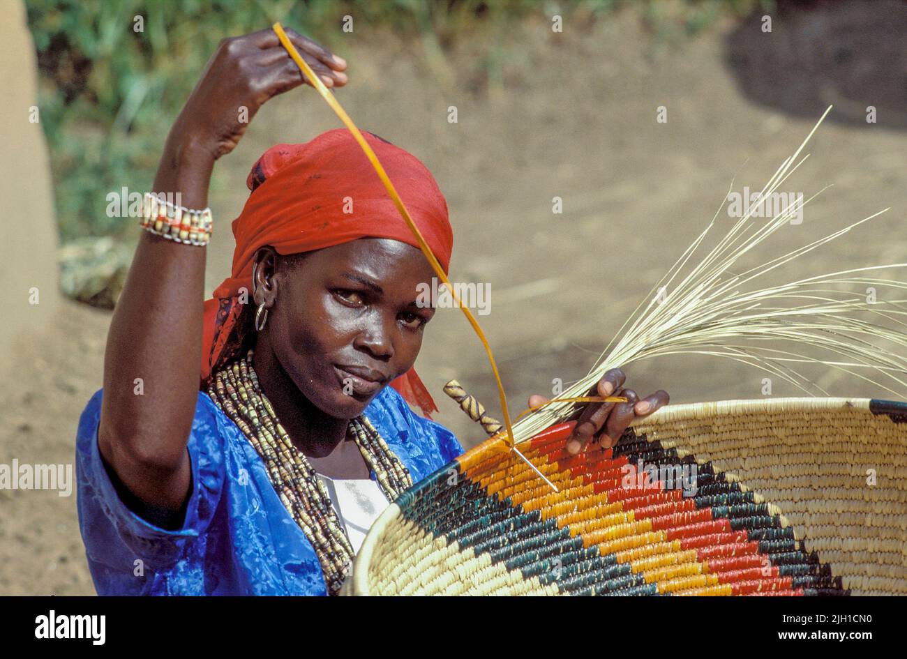 Uganda, Kampala; Portrait of a woman weaving traditional baskets Stock