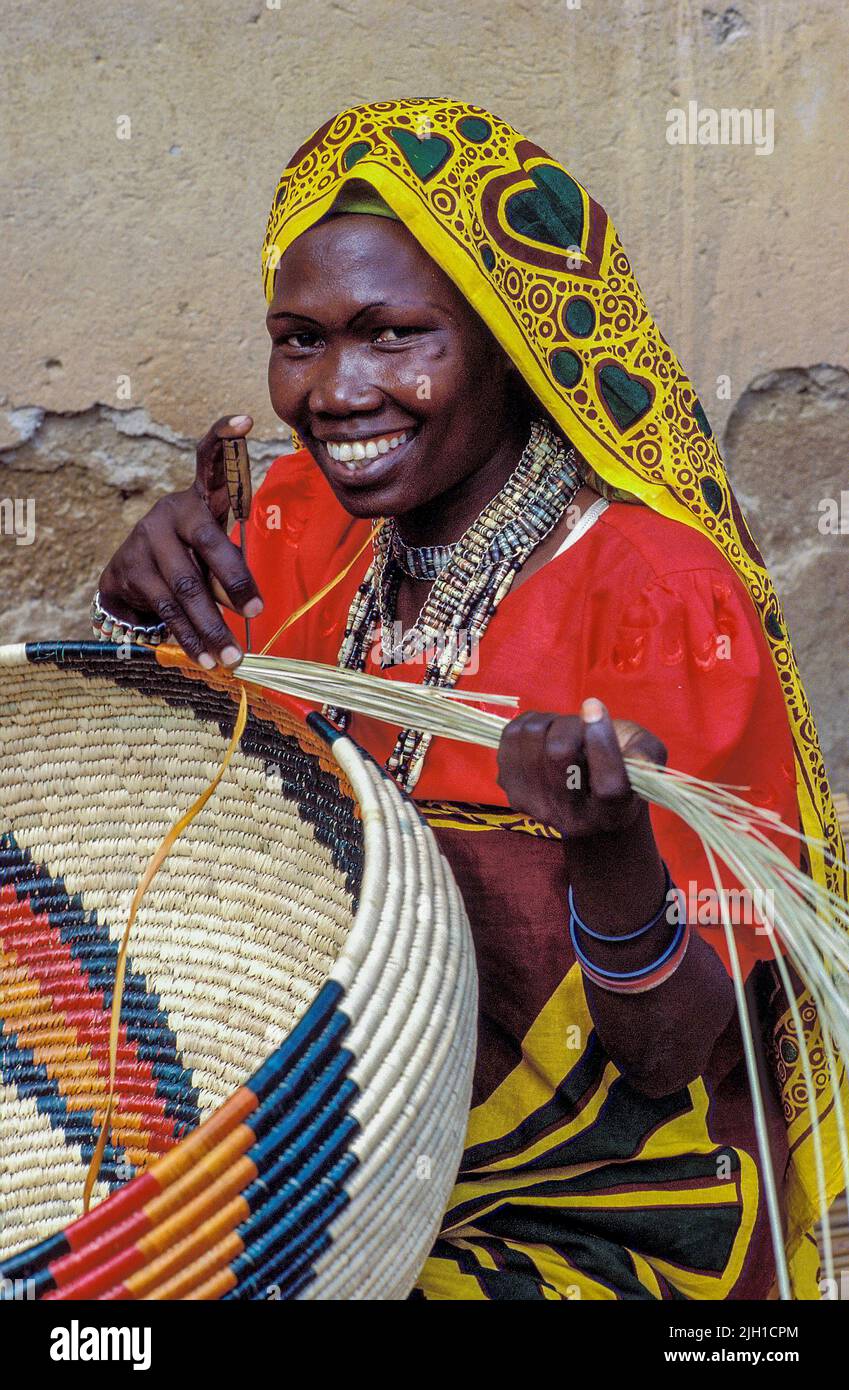 Uganda, Kampala; Portrait of a woman weaving traditional baskets Stock