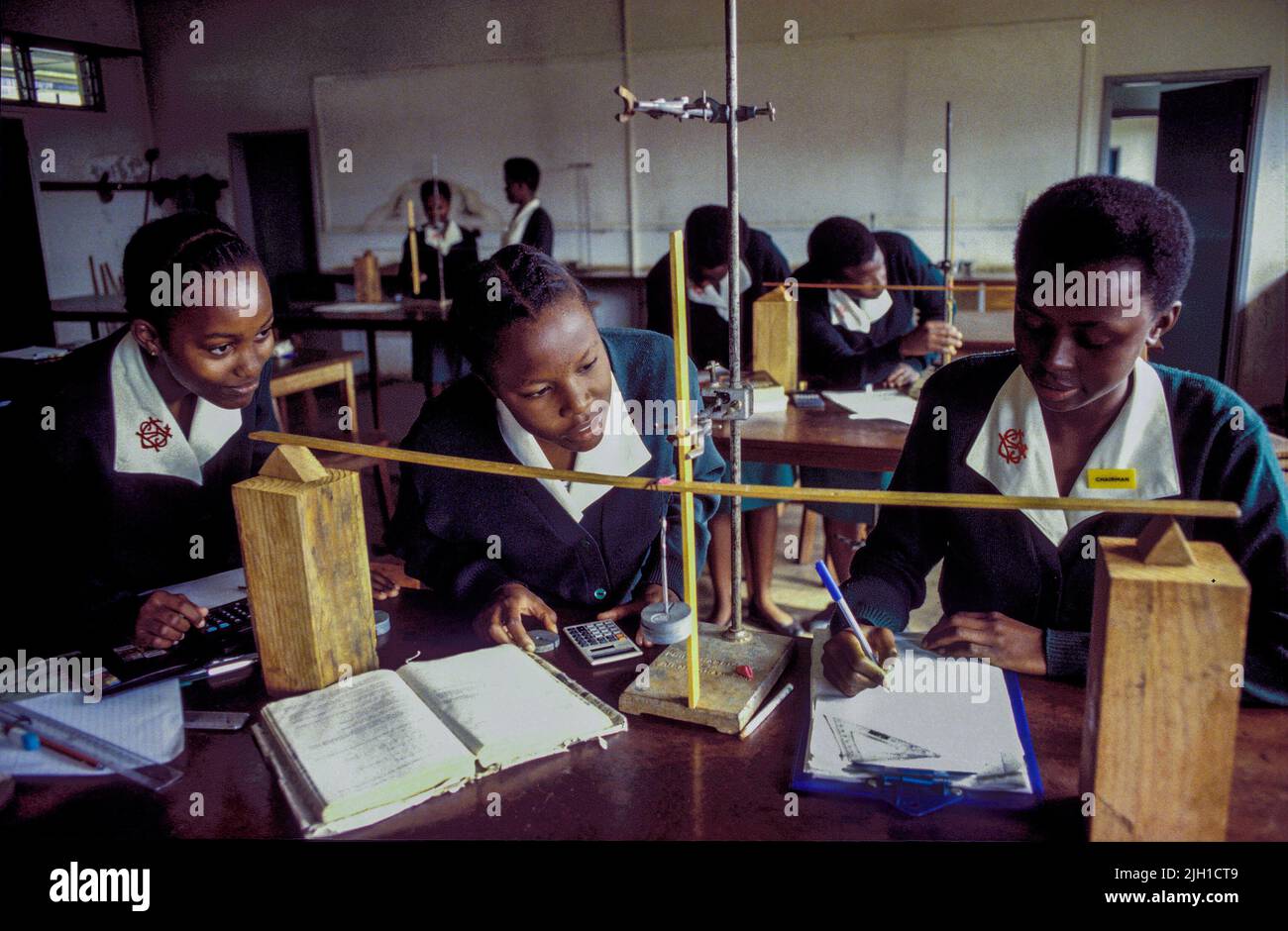 Uganda, Kampala; Three girls at a girls school at the physics class. Stock Photo