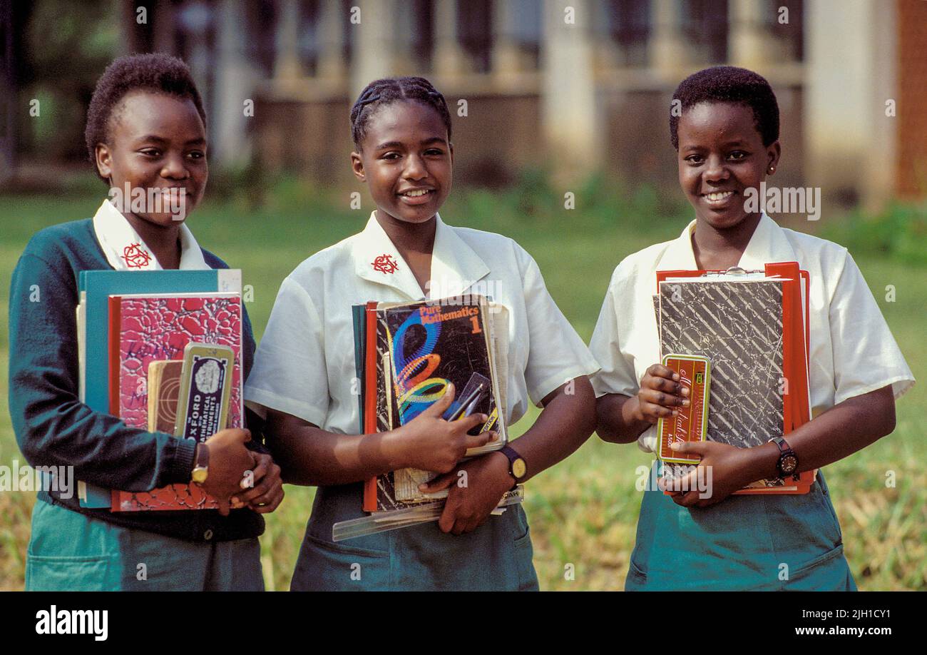 Uganda, Kampala; Portrait of three girls at the girls school holding textbooks. Stock Photo