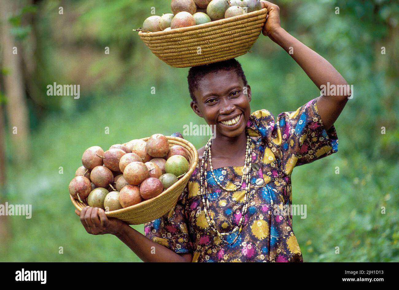 Uganda, Kampala region; woman showing baskets filled with passion