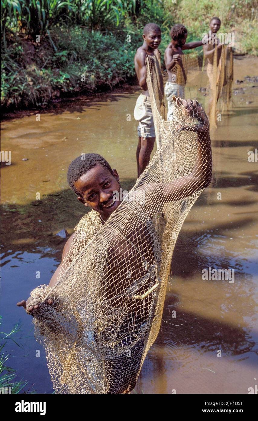 Uganda, Mbarara; Men checking the fishing nets in a fish pond Stock
