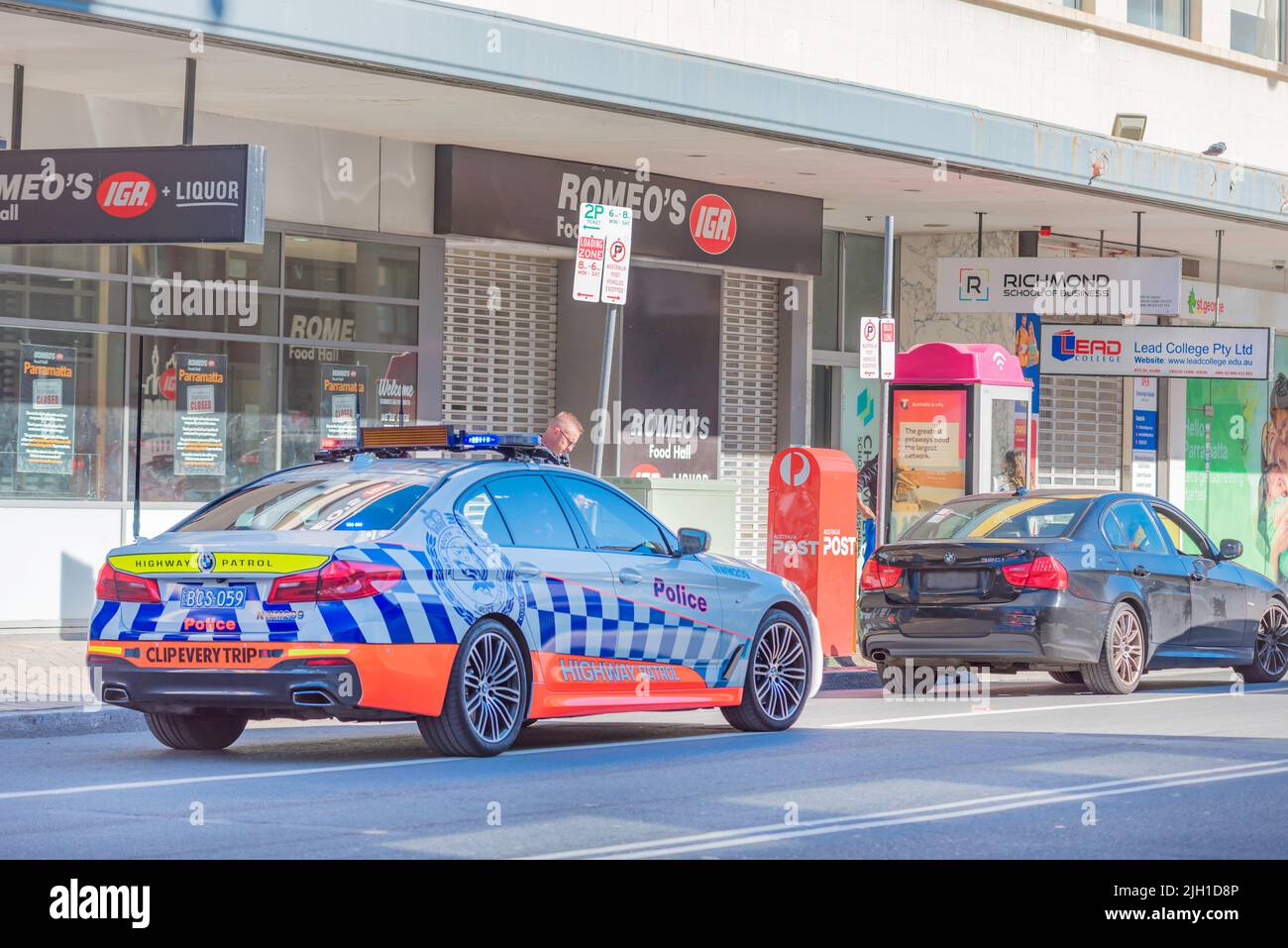 A New South Wales, Highway Patrol, Police pursuit vehicle having stopped a car. A police officer standing beside the vehicle in Parramatta, Australia Stock Photo