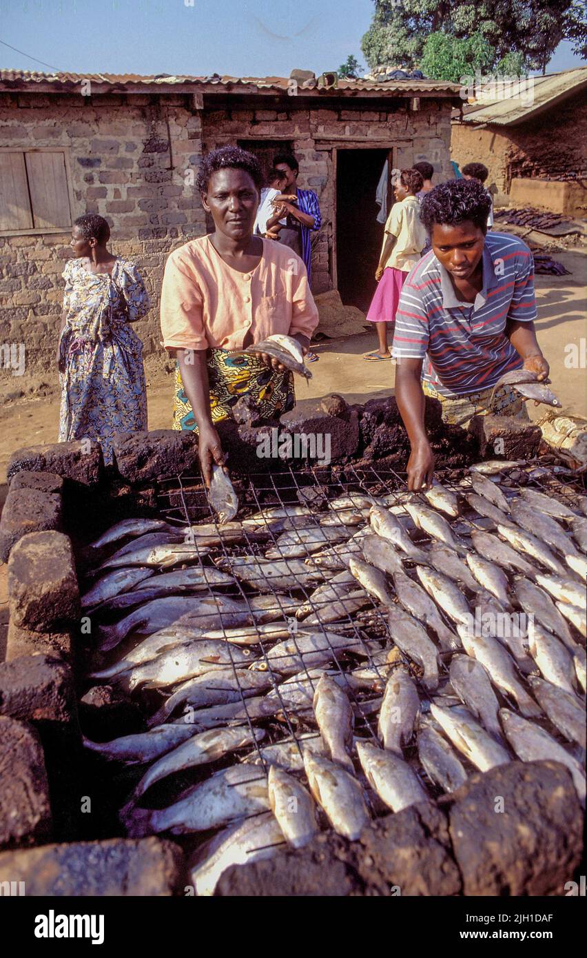 Uganda, Lake Victoria, Gaba; Women in the village smoke fish at a fireplace Stock Photo Alamy