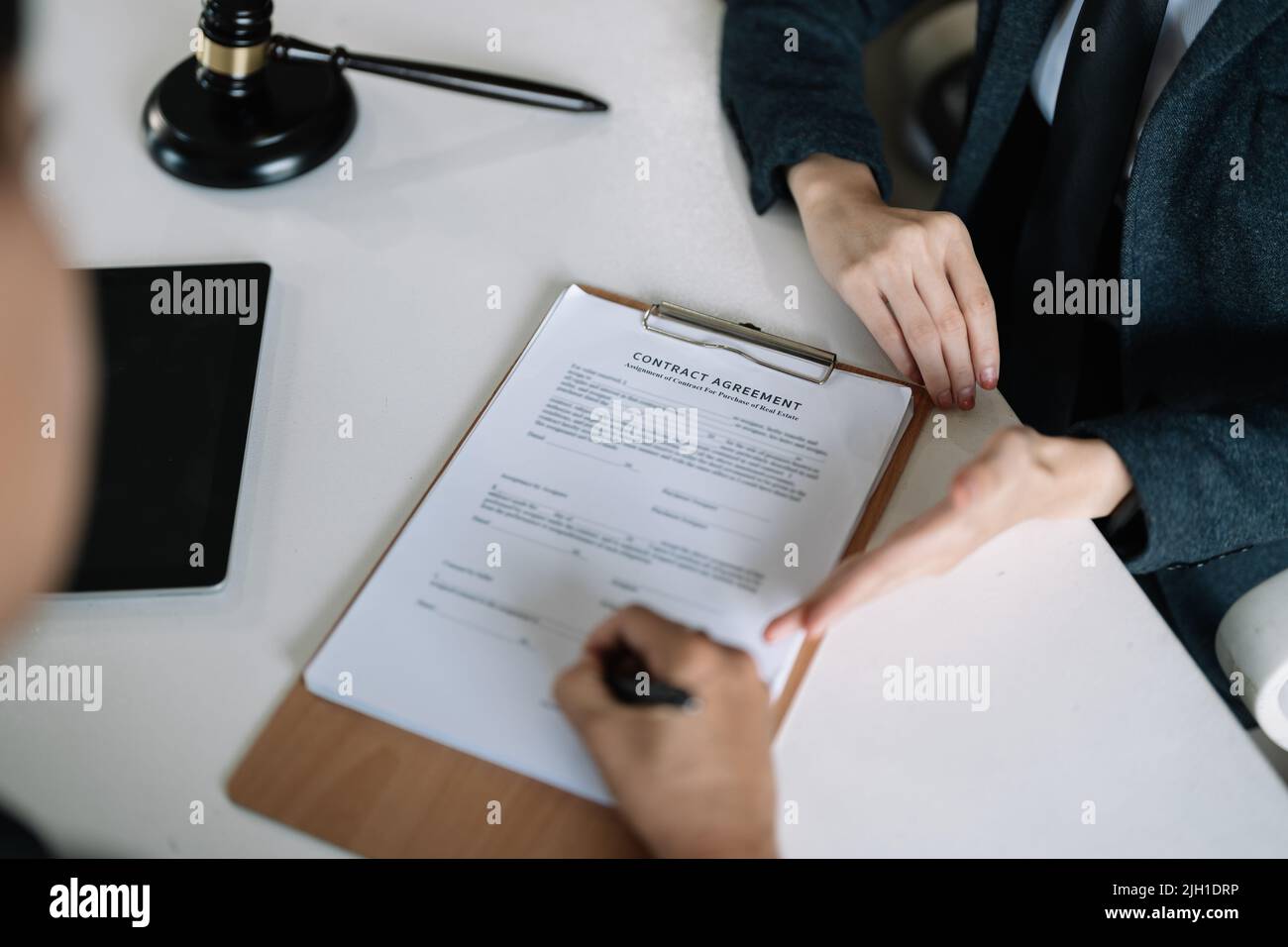 Lawyer Legal counsel presents to the client a signed contract with gavel and legal law. justice and lawyer Business partnership meeting concept. Stock Photo
